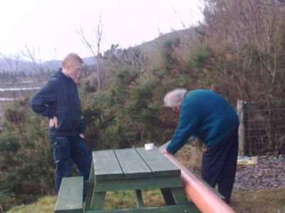 Terry giving Scott a lesson in cutting a piece of pipe.